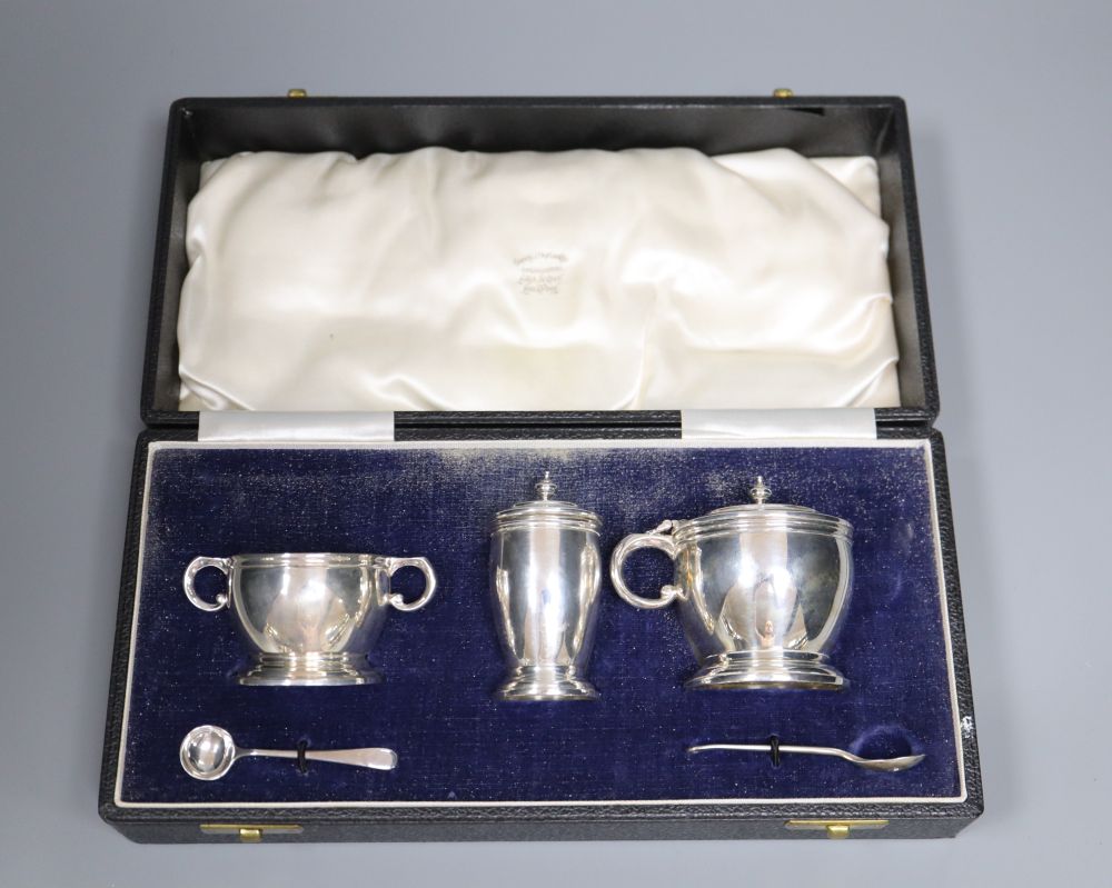 A modern cased silver three piece condiment set, with two later spoons, Wakely & Wheeler, London, 1957, 5oz.
